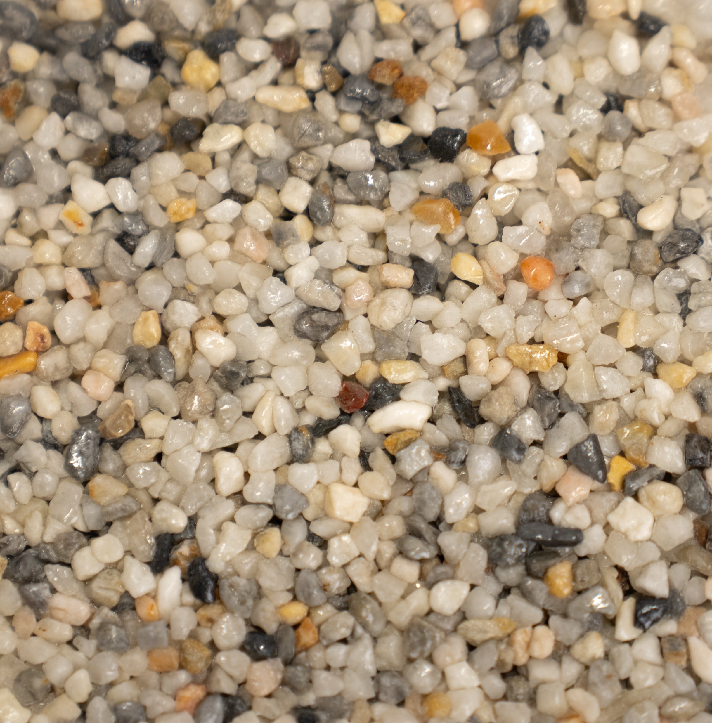 Close-up of mini pearl pebbles with various colors including white, gray, with hints of orange.