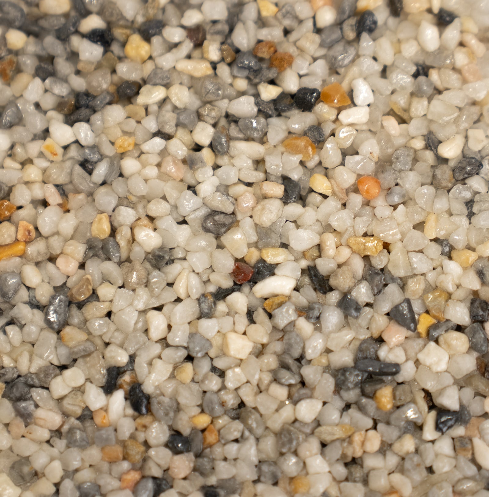Close-up of mini pearl pebbles with various colors including white, gray, with hints of orange.
